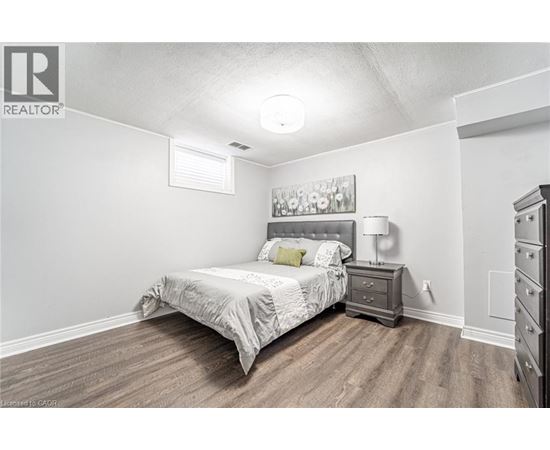 A bedroom with a bed, nightstand, and dresser.