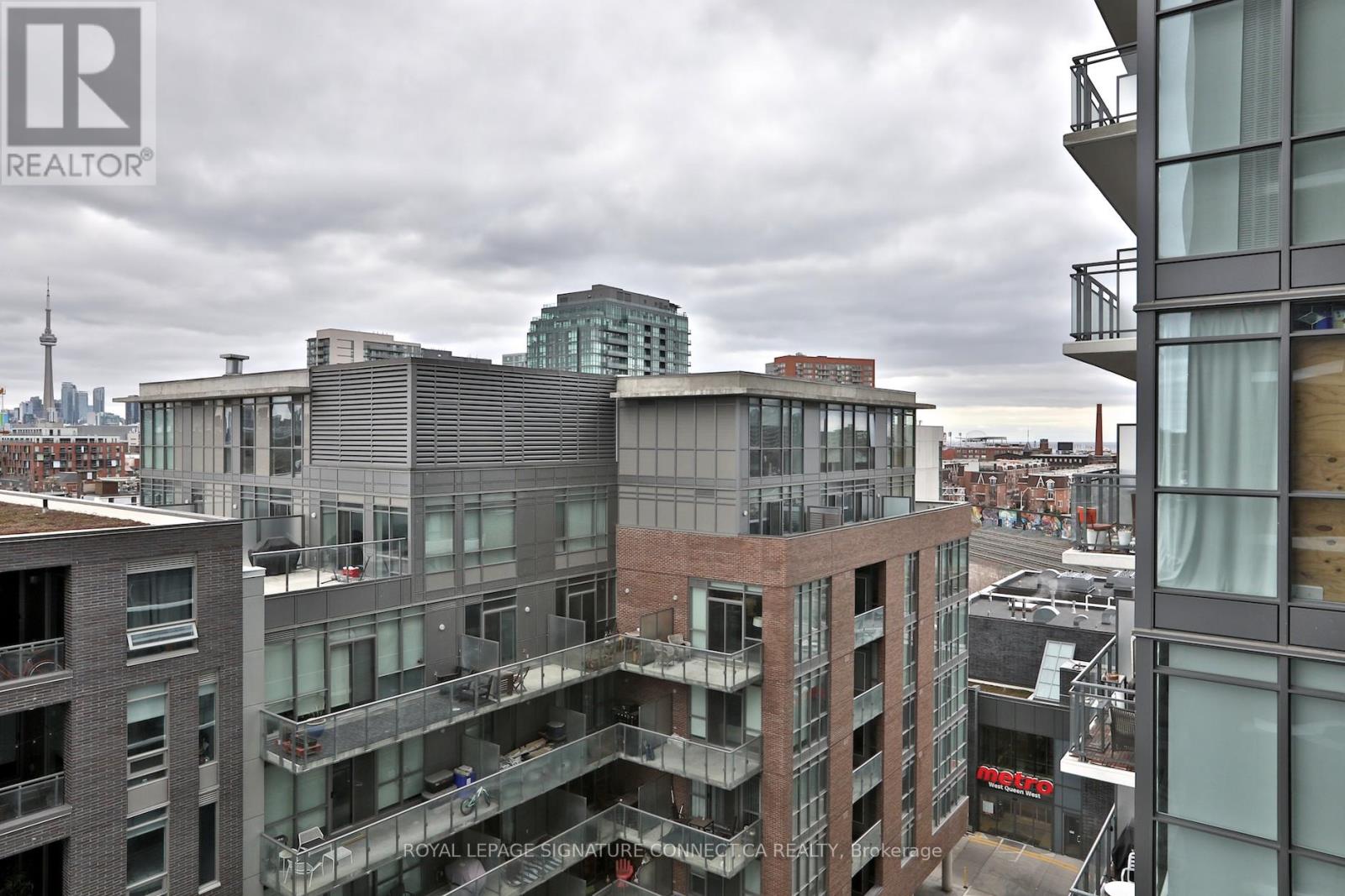 A view of a cityscape with buildings and a cloudy sky.