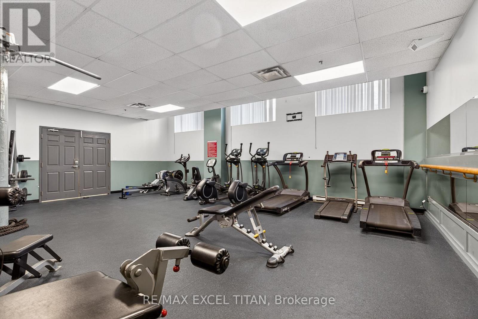 A gym with a variety of equipment including treadmills, weights, and exercise machines.