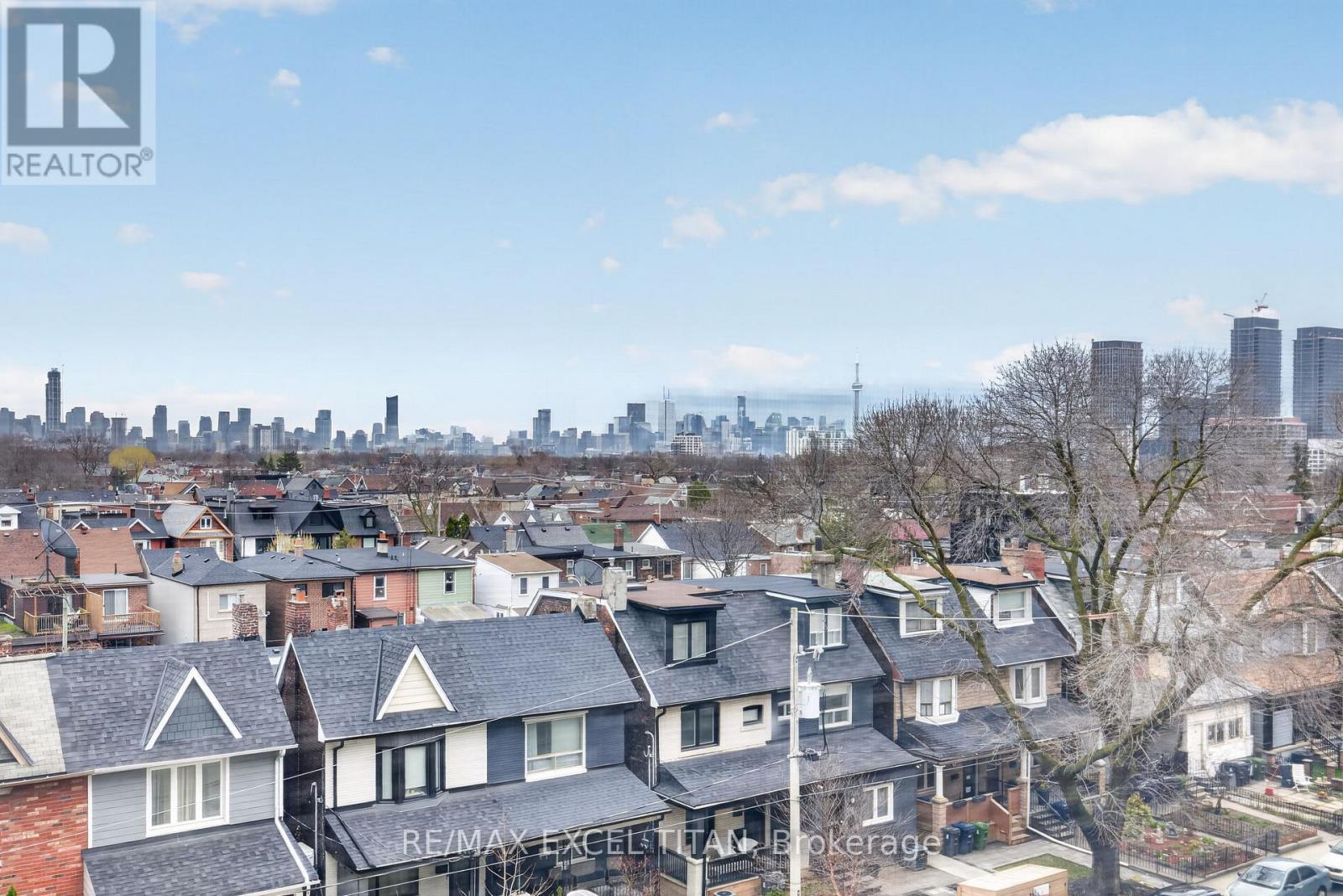 A view of a residential area with houses and a city skyline in the distance.