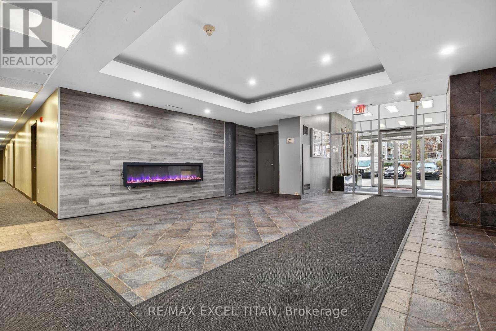 A lobby with a stone wall and a fireplace.