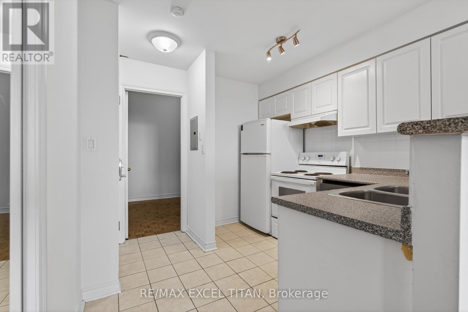 A kitchen with white cabinets and appliances.