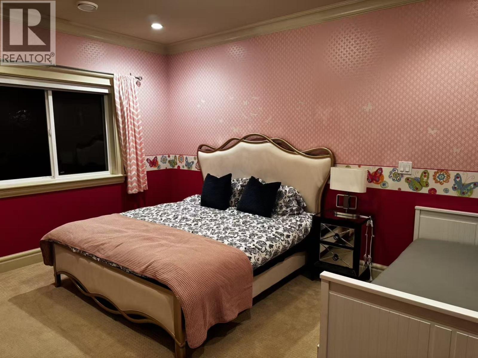 A bedroom with a bed, nightstand, and window.