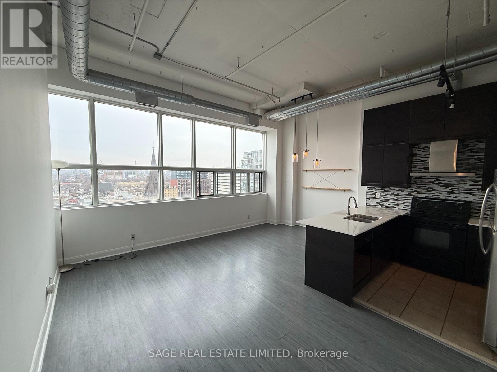 A spacious kitchen and living room with a view of the city.