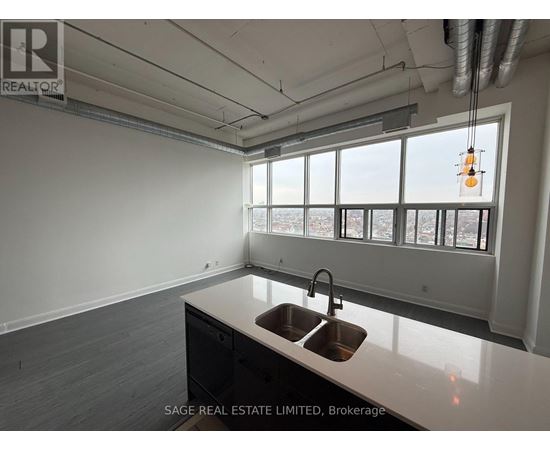 A kitchen with a sink and a window overlooking a cityscape.