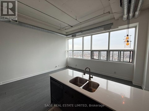 A kitchen with a sink and a window overlooking a cityscape.