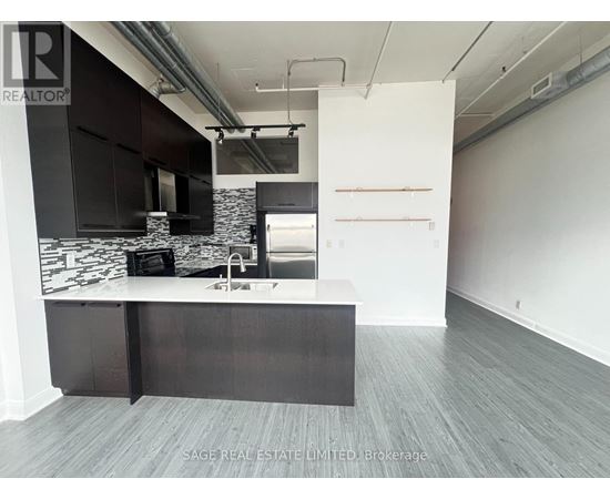A modern kitchen with a black and white marble backsplash and dark wood flooring.