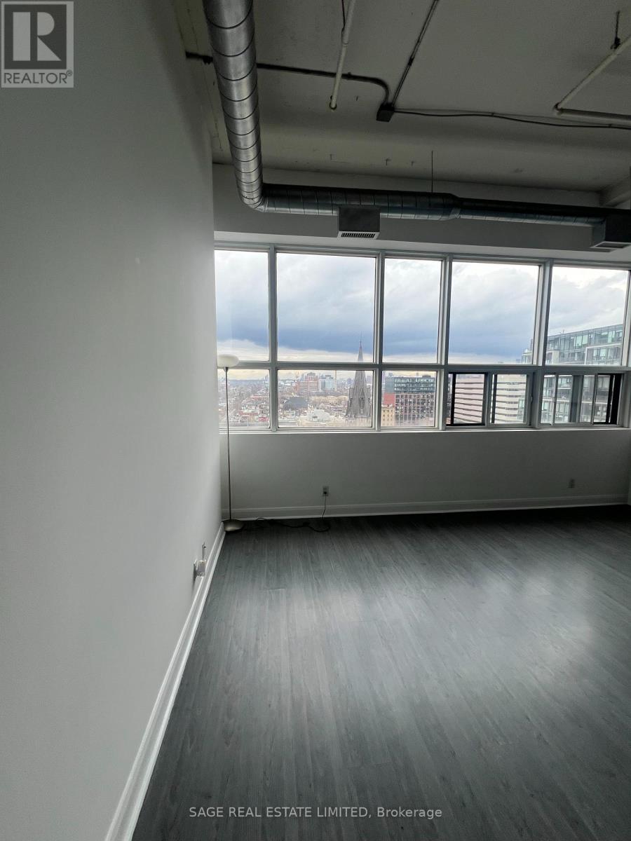 A room with a view of the city through large windows.