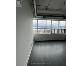 A room with a view of the city through large windows.