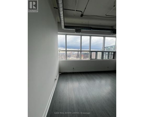A room with a view of the city through large windows.