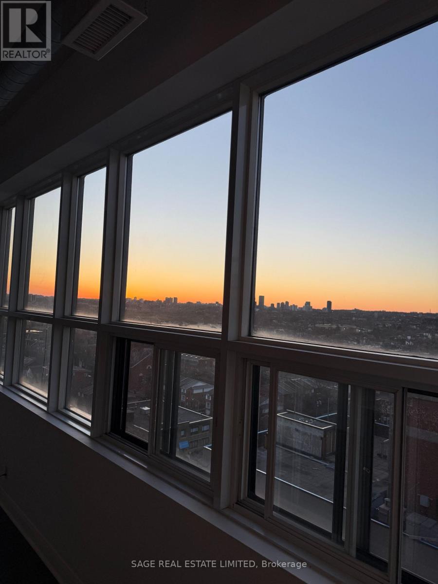 A view of a city skyline through a window at sunset.