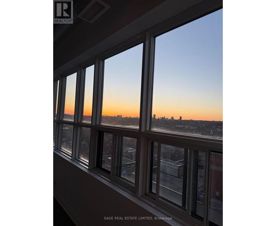 A view of a city skyline through a window at sunset.