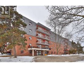 A large apartment building with a red brick facade and multiple balconies.
