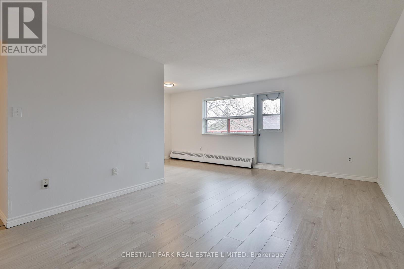 A spacious room with a window and a radiator.