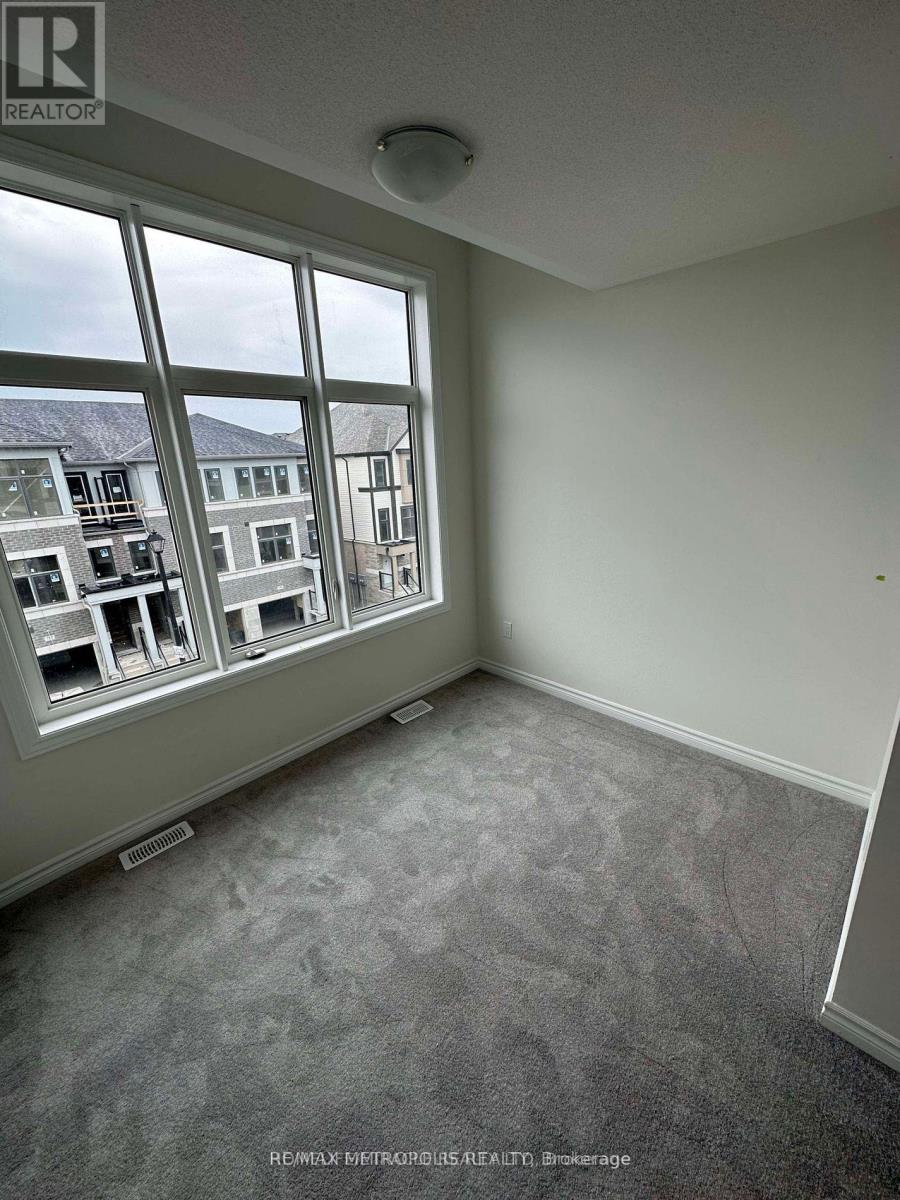 A room with a large window overlooking a street with buildings.