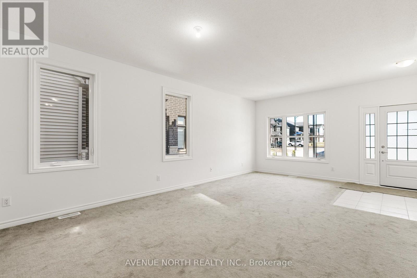 A spacious room with a large window and a door, all ready for a new tenant.