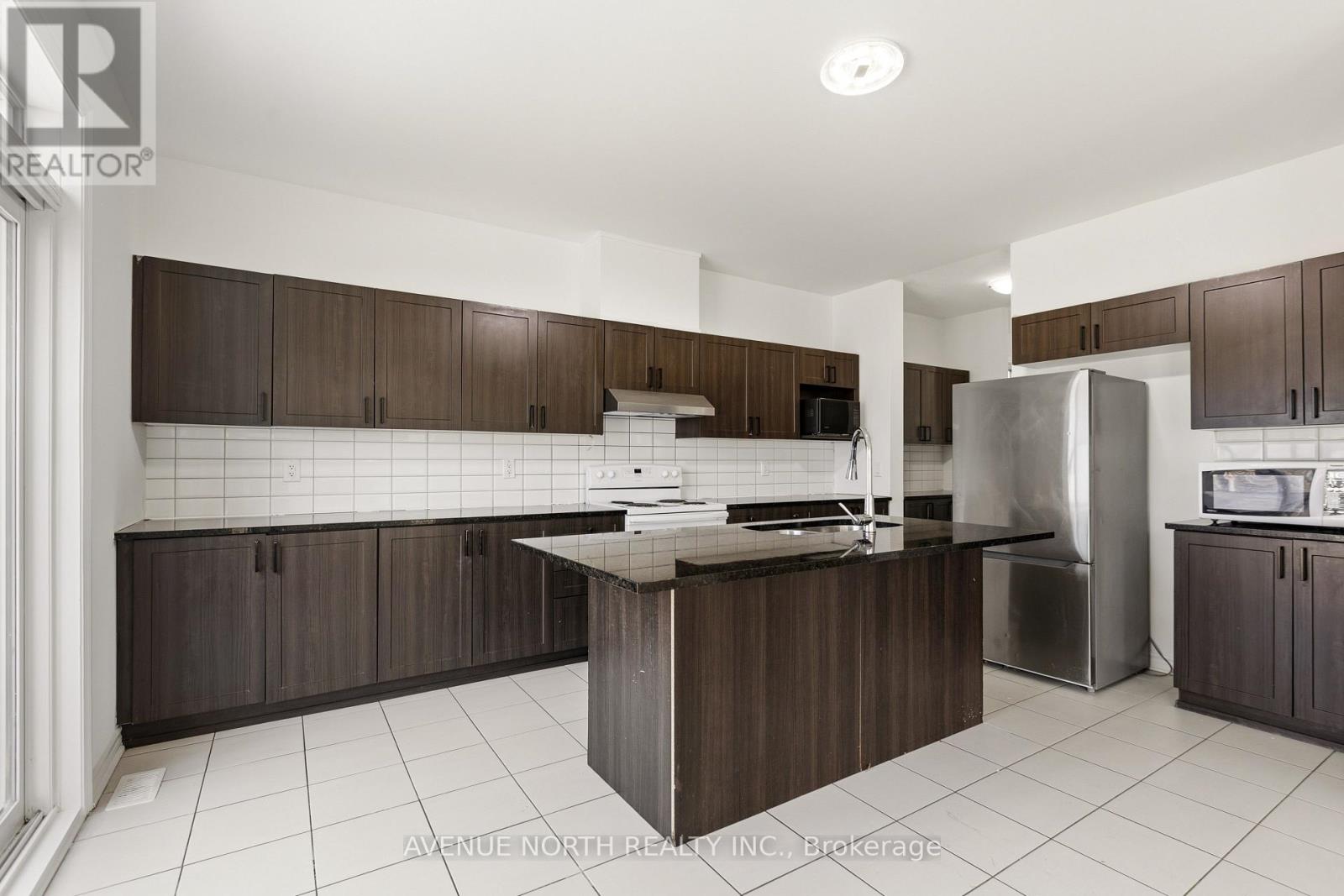 A modern kitchen with dark brown cabinets and a central island.