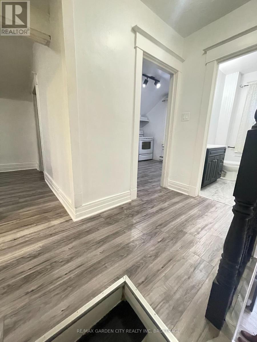 A room with wooden flooring and white walls.