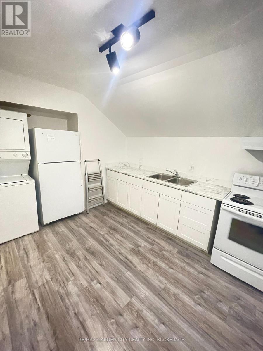 A kitchen with white appliances and wood flooring.