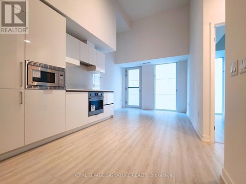 A kitchen with white cabinets and a microwave.