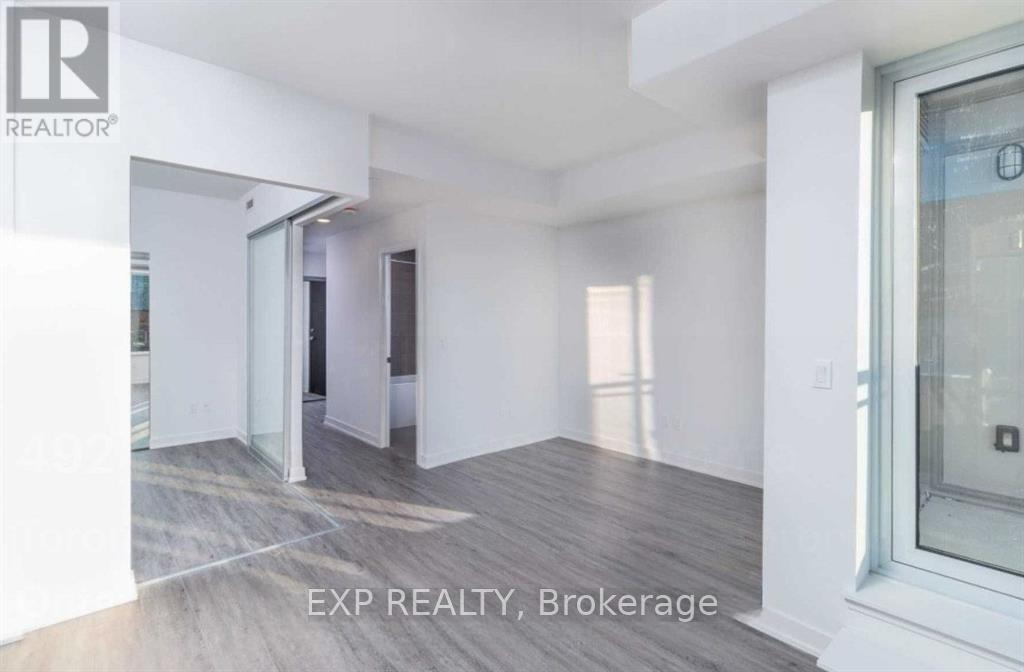 A room with white walls and a wooden floor is on the market through EXP REALTY Brokerage.