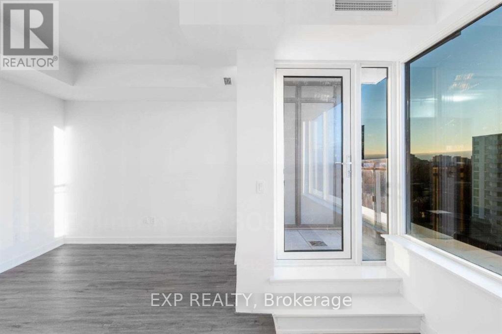 A room with a large window and a door leading outside.