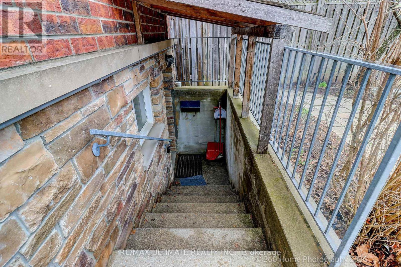 A staircase with a metal railing leads down to a small basement area.