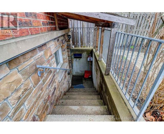 A staircase with a metal railing leads down to a small basement area.