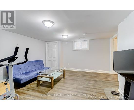A living room with a blue couch and a glass coffee table.