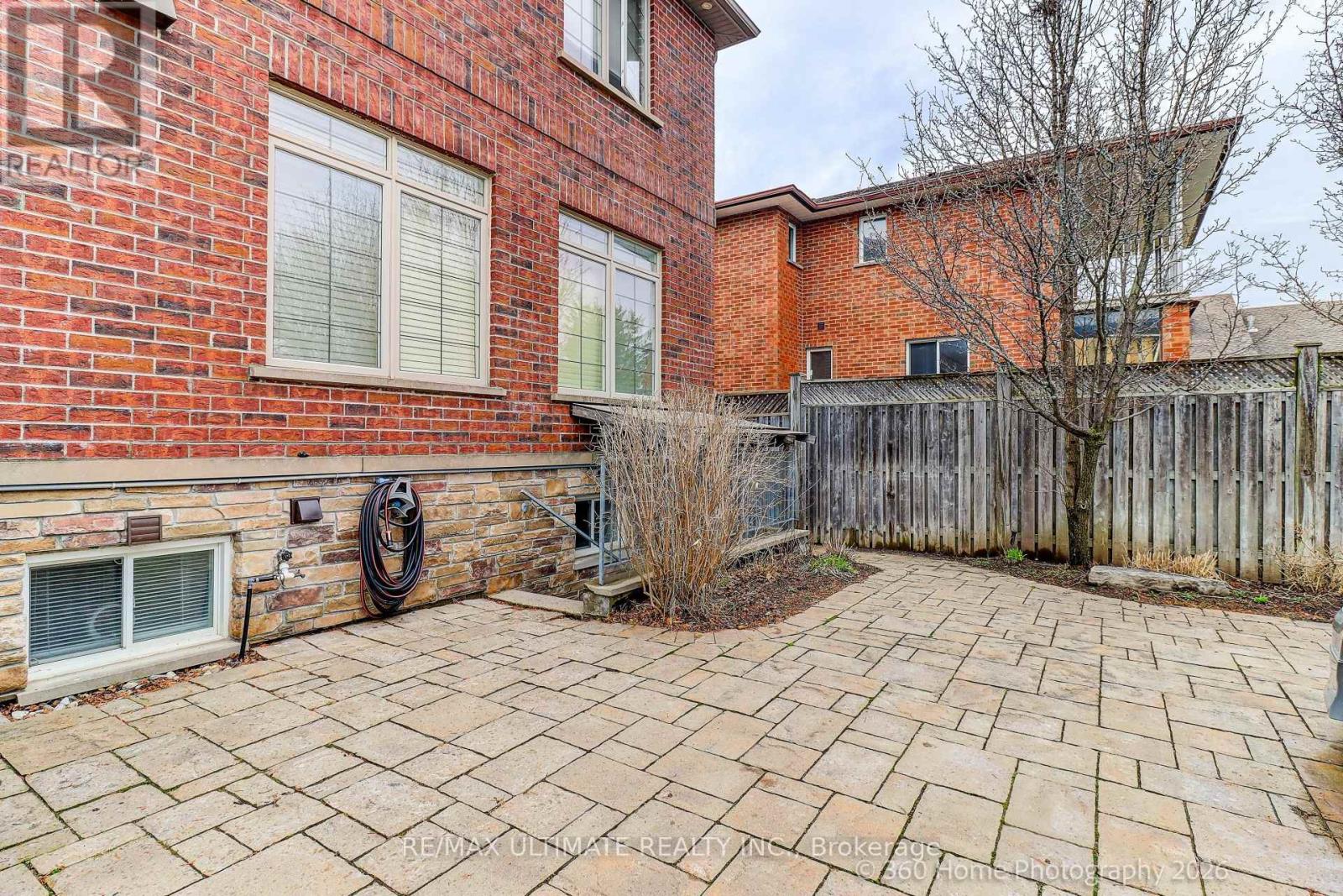 A brick house with a patio and a tree.