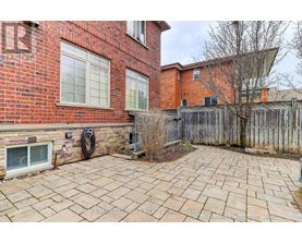 A brick house with a patio and a tree.