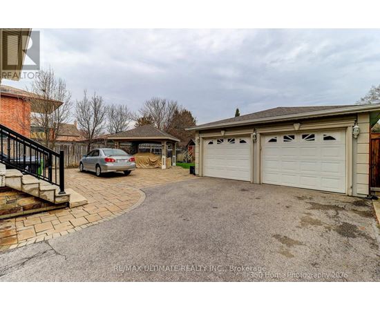 A car is parked in front of a house with a white garage door.