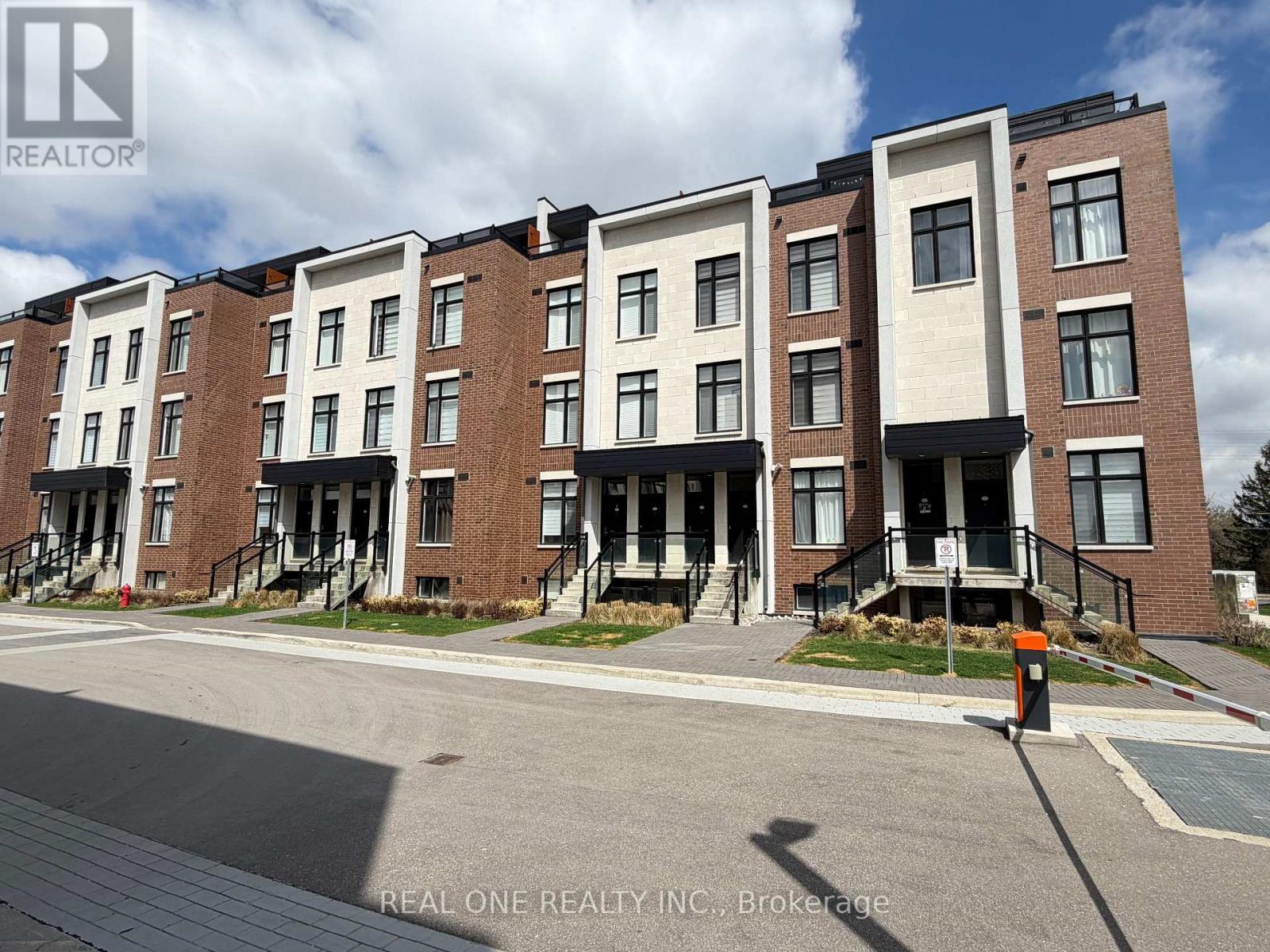 A row of townhouses with the logo REAL ONE REALTY INC. on the bottom left.