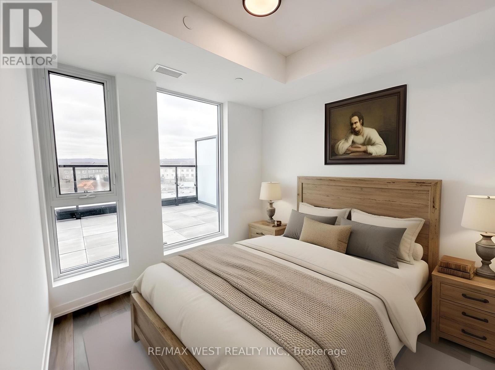 A bedroom with a large bed, a window with a view, and a painting on the wall.