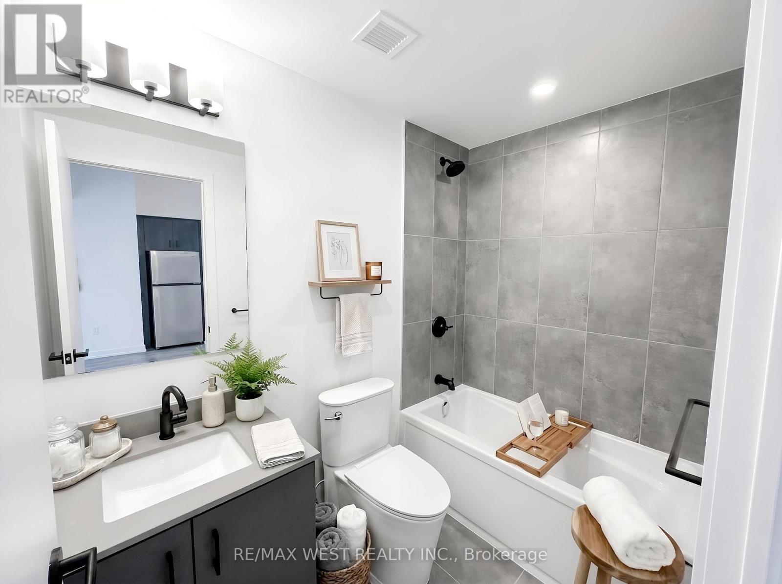 A bathroom with a white toilet, sink, and bathtub.