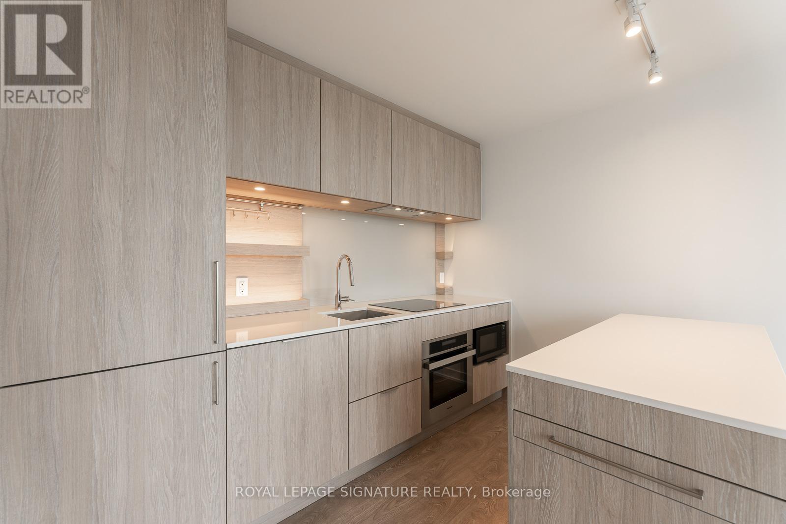 A modern kitchen with wooden cabinets and a white countertop.