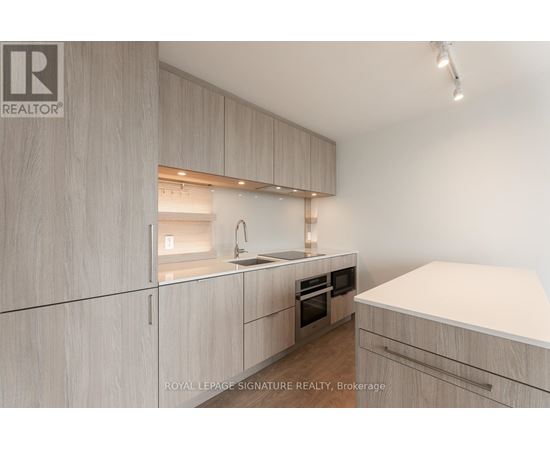 A modern kitchen with wooden cabinets and a white countertop.