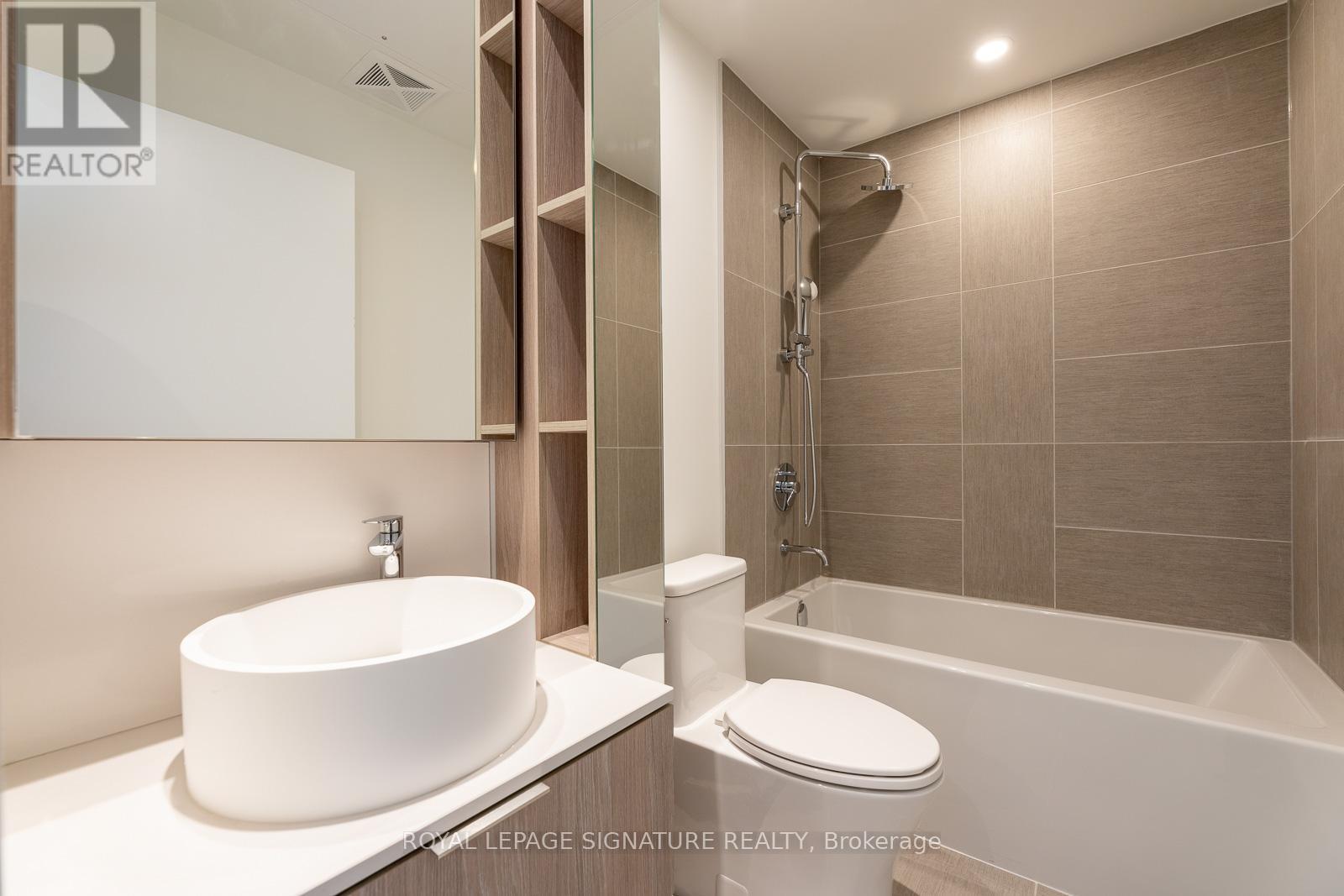 A modern bathroom with a white sink and a white toilet.