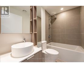 A modern bathroom with a white sink and a white toilet.