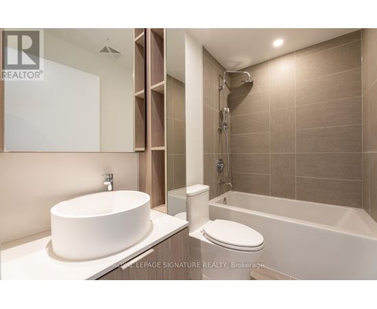 A modern bathroom with a white sink and a white toilet.