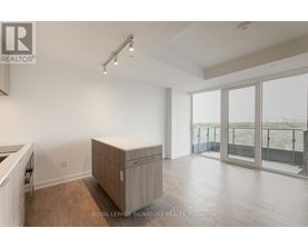 A spacious room with a sliding glass door leading to a balcony.