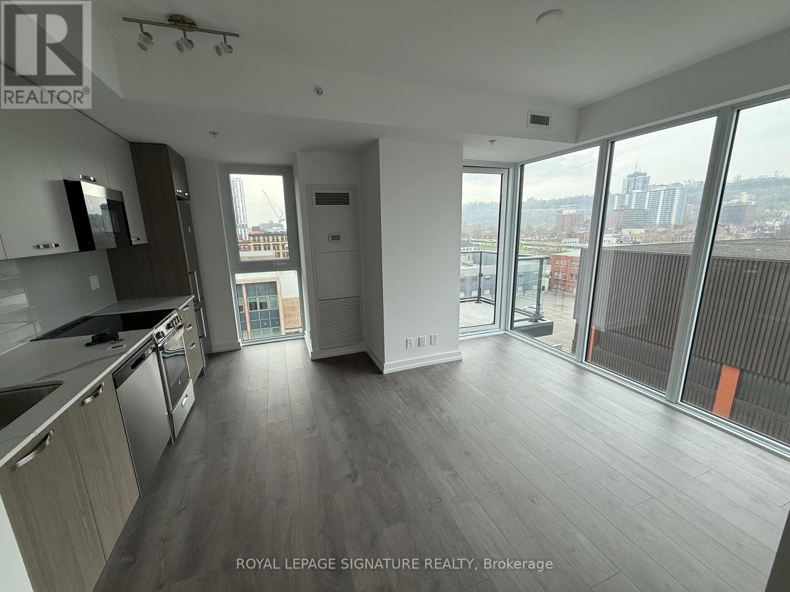 A spacious kitchen and living room with a view of the city.