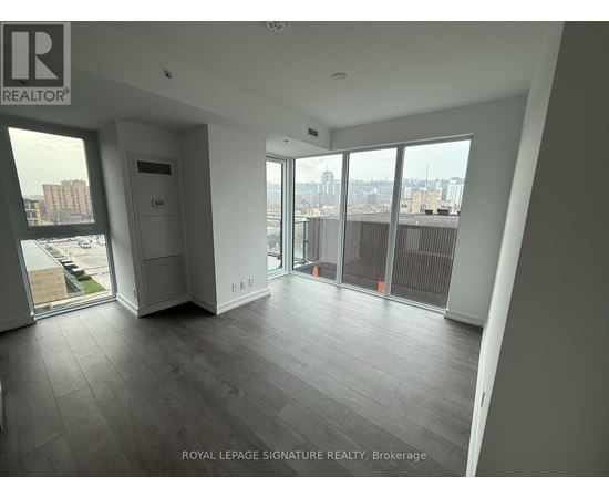 A spacious room with a view of the cityscape through large windows.