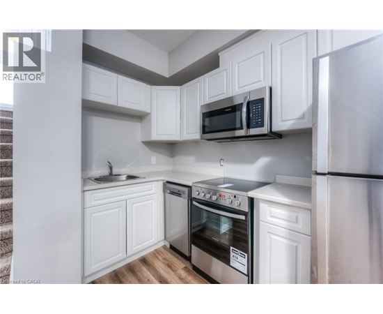 A modern kitchen with white cabinets and stainless steel appliances.
