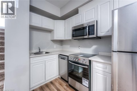 A modern kitchen with white cabinets and stainless steel appliances.