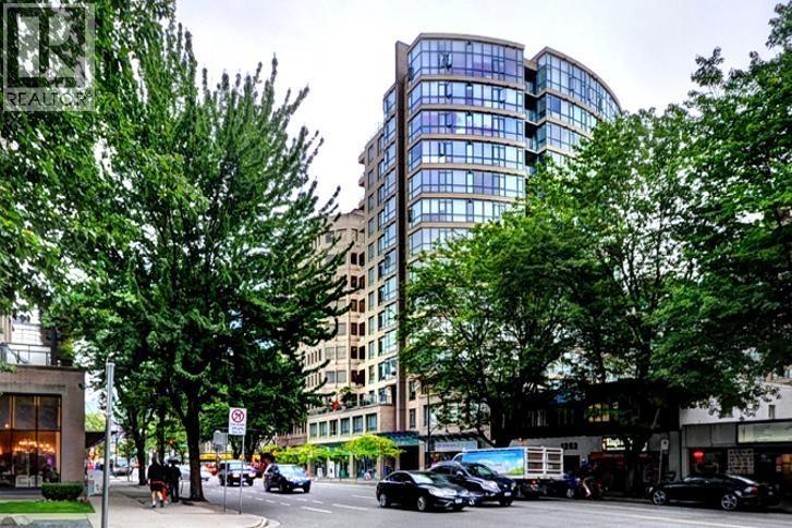 A street view with cars and a tall building.
