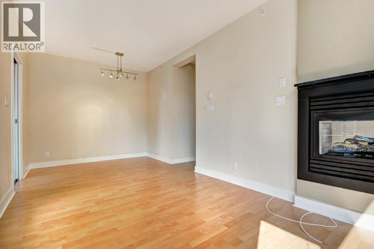 A living room with a fireplace and a wooden floor.