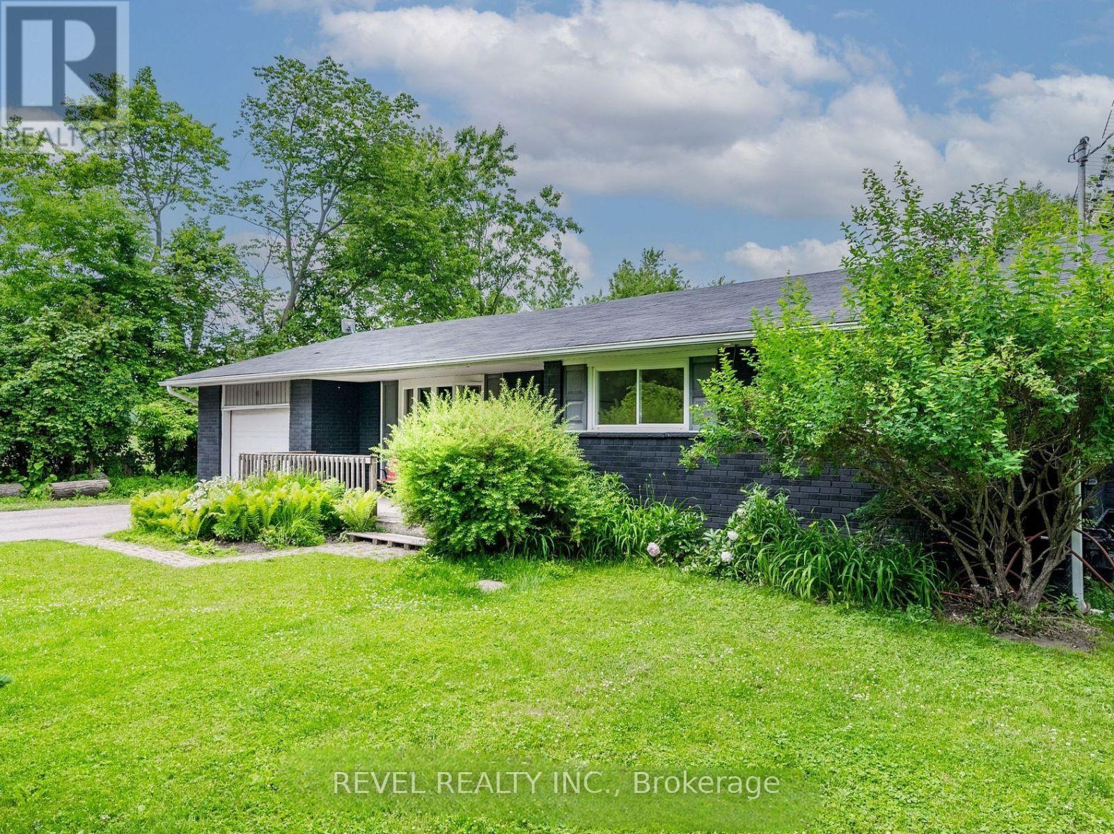 A house with a green lawn and trees in the background.