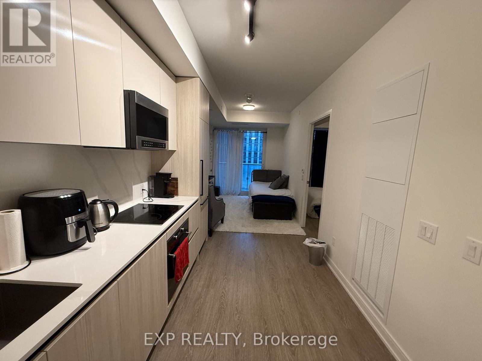 A kitchen with white cabinets and a black coffee maker.