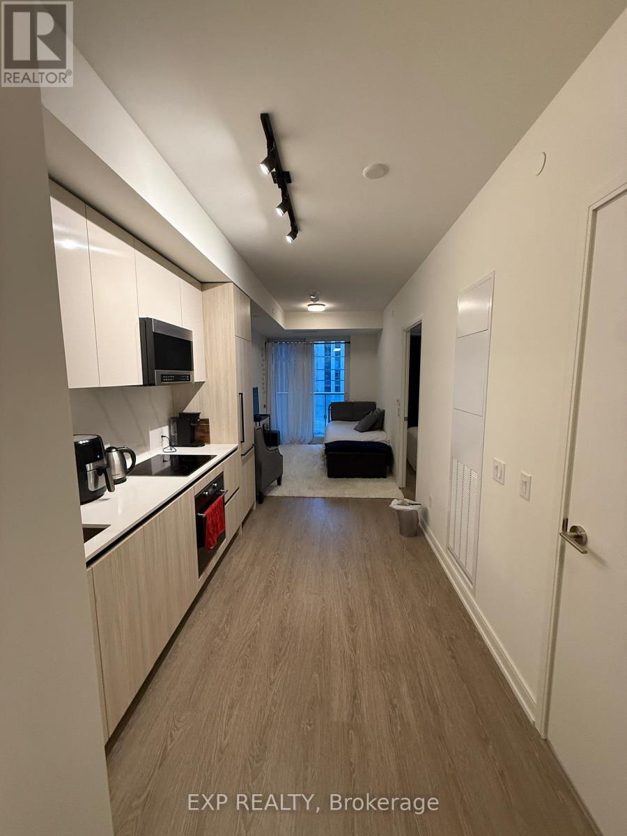 A kitchen with white cabinets and a microwave.